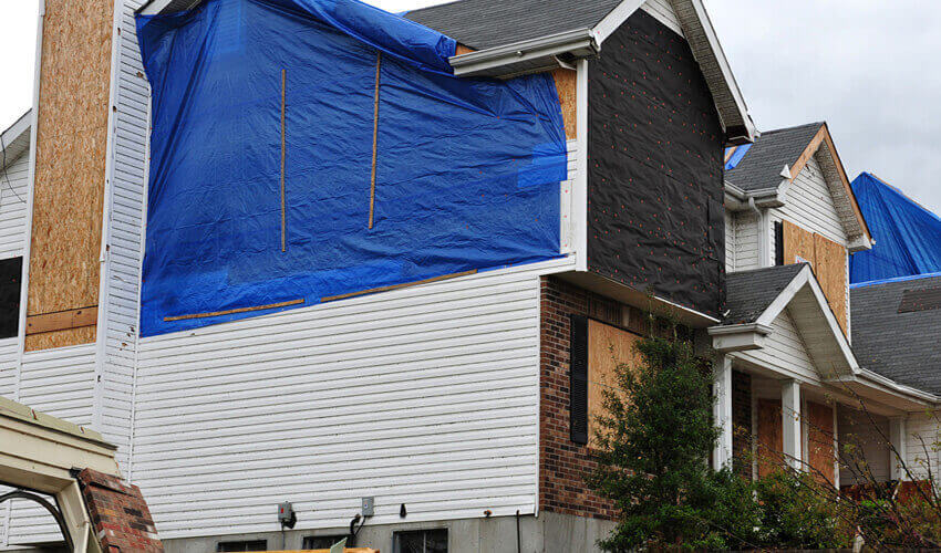 house-covered-in-tarps-from-a-roof-leak