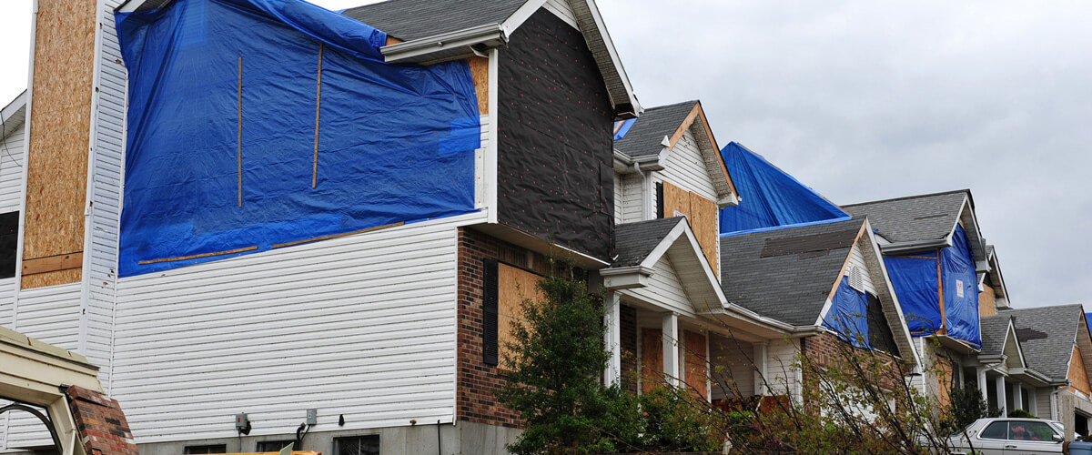 house-covered-in-tarps-from-a-roof-leak